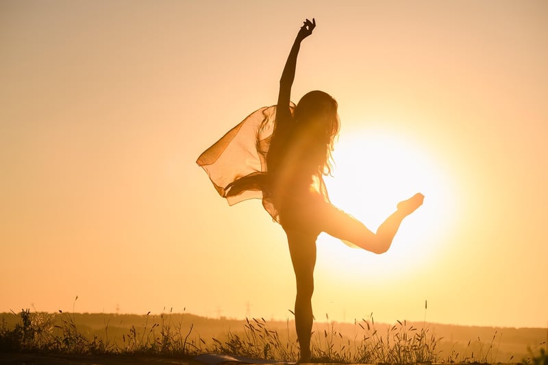Woman practicing yoga at sunset